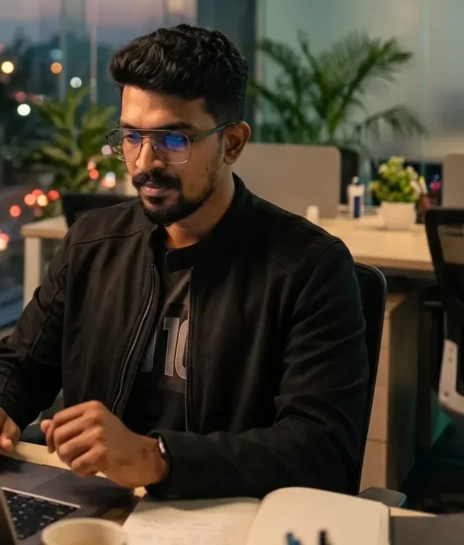 Close-up of a man at a laptop analysing performance analytics in a glass office above city lights